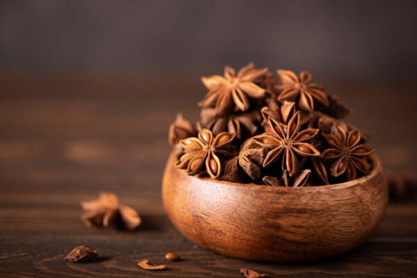 star anise in a wooden bowl on the table, close up Star Anise