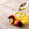 Palm oil in glass bowl and fresh palm fruit on wooden table background. Palm Oil